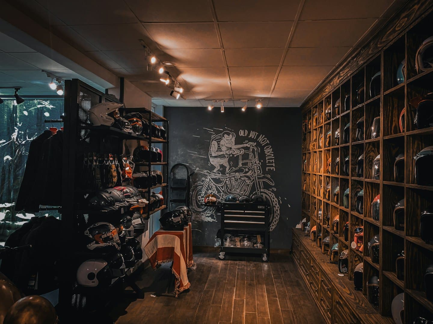 Kaski motocyklowe wyeksponowane na półkach w salonie.