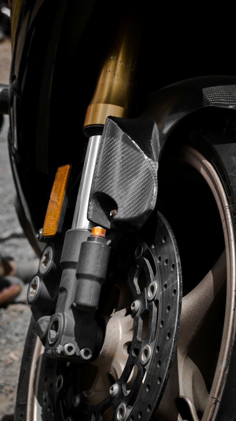 Skomplikowane metalowe części przedniego koła motocykla.
